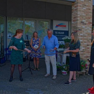 Wethouder Ron de Haan zaagt een tak door bij de opening van het Reisburo